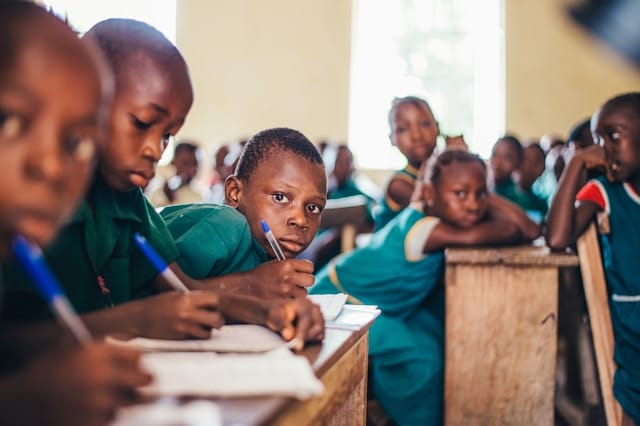 Children learning together in a classroom supported by education programs